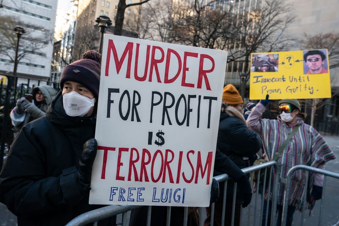 Protestors hold signs outside of Manhattan Criminal Court on December 23, 2024 in New York City.