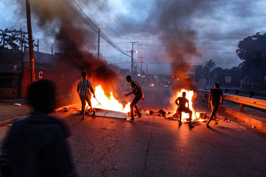 Protesters gather next to a burning barricade in Maputo on December 23, 2024.