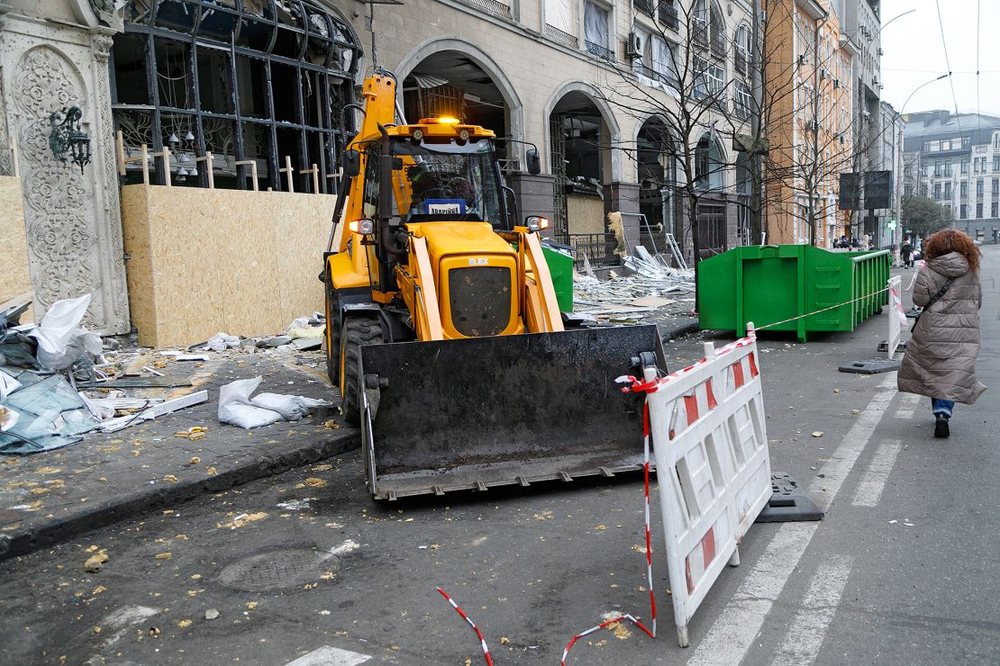 A bucket loader is used to clear rubble from Antonovycha Street in Kyiv's Holosiivskyi district after a Russian missile attack, in December 2024.