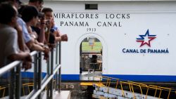 Tourists watch a cargo ship transit through the Panama Canal in Panama City on December 23, 2024. US President-elect Donald Trump has threatened to demand control of the Panama Canal be returned to Washington, complaining of "unfair" treatment of American ships and hinting at China's growing influence. (Photo by ARNULFO FRANCO / AFP) (Photo by ARNULFO FRANCO/AFP via Getty Images)