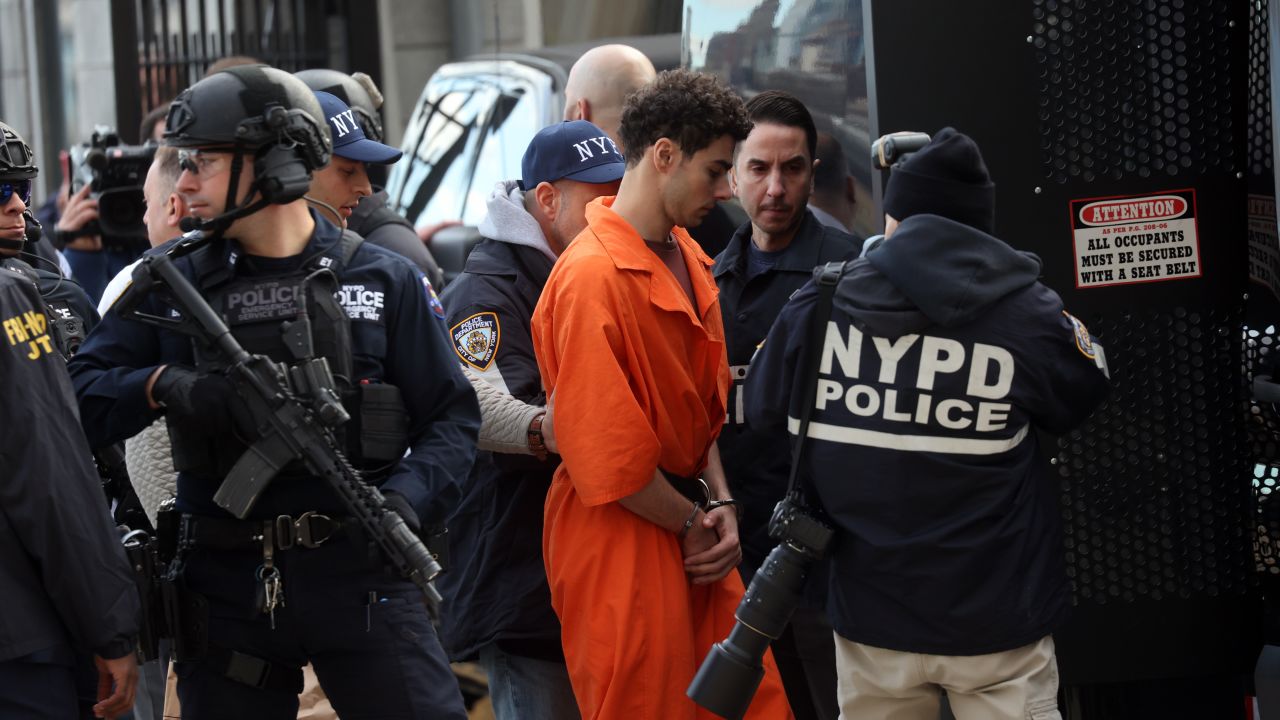 NEW YORK, NEW YORK - DECEMBER 19: Luigi Mangione, suspect in the killing of UnitedHealthcare CEO Brian Thompson in New York City, arrives at a heliport with members of the NYPD on December 19, 2024 in New York City. The 26-year-old was arrested in Pennsylvania on December 9 after being spotted at a McDonald's in Altoona amid a national manhunt. Mangione also appeared in a Pennsylvania court on forgery and firearms charges today, where he waived extradition to New York after being indicted on 11 charges including first-degree murder in furtherance of terrorism. (Photo by Spencer Platt/Getty Images)