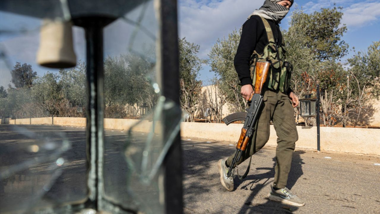 A rebel fighter walks in a military base in the capital Damascus on December 26, 2024. (Photo by Sameer Al-DOUMY / AFP) (Photo by SAMEER AL-DOUMY/AFP via Getty Images)