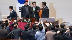 South Korea's ruling People Power Party lawmakers, bottom, argue to National Assembly Speaker Woo Won-shik, center top, during the plenary session for the impeachment vote of acting president Han Duck-soo at the National Assembly in Seoul on December 27, 2024.