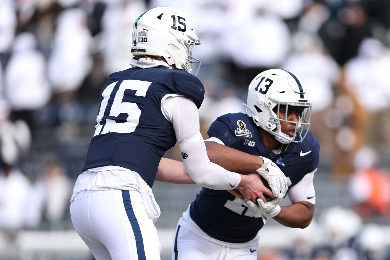 STATE COLLEGE, PENNSYLVANIA - DECEMBER 21: Drew Allar #15 hands the ball to Kaytron Allen #13 of the Penn State Nittany Lions prior to the Playoff First Round Game against the Southern Methodist Mustangs at Beaver Stadium on December 21, 2024 in State College, Pennsylvania. (Photo by Scott Taetsch/Getty Images)