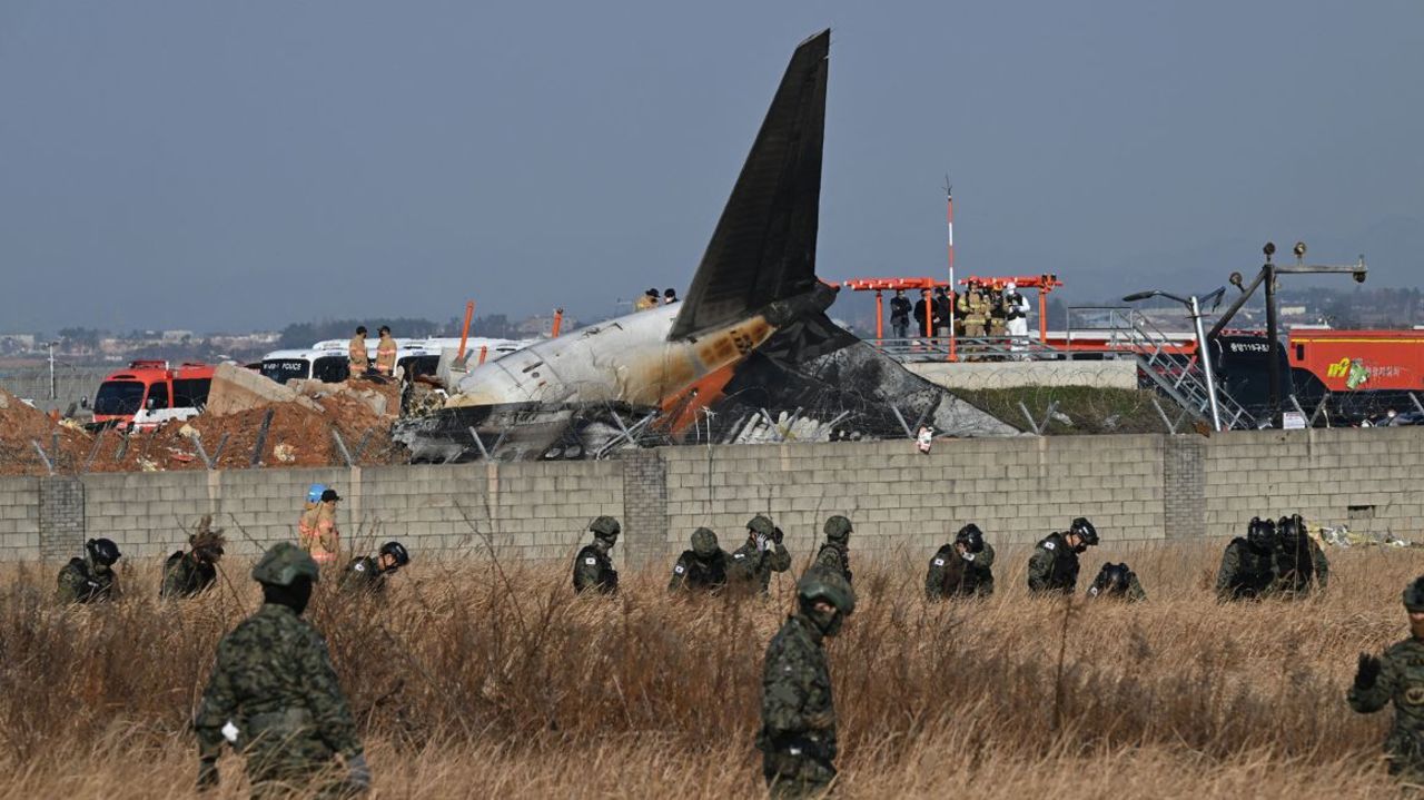 Soldados surcoreanos buscan a pasajeros desaparecidos cerca de los restos de un Boeing 737-800 de Jeju Air después de que el avión se estrellara y estallara en llamas en el Aeropuerto Internacional de Muan, en la provincia de Jeolla del Sur.