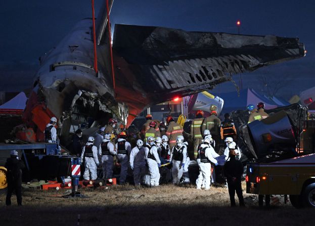 Firefighters and rescue personnel carry the body of a victim at Muan International Airport in South Korea on Sunday, December 29.