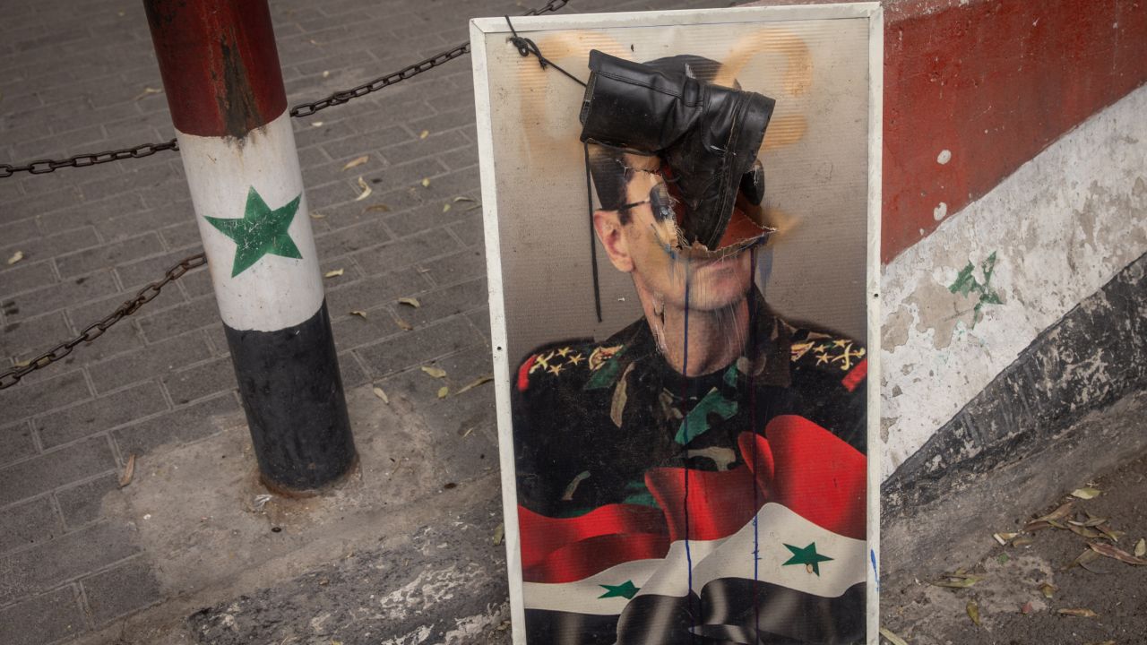 DAMASCUS, SYRIA - DECEMBER 22: A defaced poster of Bashar al-Assad is seen outside a Syrian Army recruitment center on December 22, 2024 in Damascus, Syria. On December 8, rebel forces in Syria retook the capital and several other cities from longtime ruler Bashar al-Assad, who fled the country for Moscow. The fall of the Assad regime marks a new chapter for Syria, which has been mired in a multi-party civil war since 2011, sparked by the Arab Spring uprisings. (Photo by Chris McGrath/Getty Images)