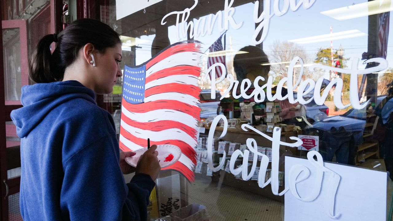 PLAINS, GEORGIA - DECEMBER 30: Morgan Minick paints a sign thanking former President Jimmy Carter in his home town after he passed away yesterday, on December 30, 2024 in Plains, Georgia. President Carter lived to be 100 years old, making him the longest living U.S. President in history. He was known as much for his long post-presidency and continued life of service as he was for his one term in office. He played a pivotal role in negotiating of the Camp David Accords, and earned the Nobel Peace Prize in 2002. (Photo by Megan Varner/Getty Images)