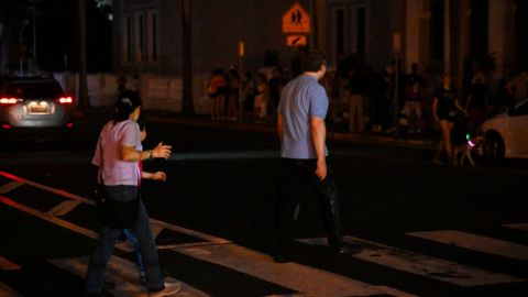 SAN JUAN, PUERTO RICO - DECEMBER 31: People walk on a dark street on December 31, 2024 in San Juan, Puerto Rico. The majority of the population on the island is without electricity due to a major power outage.