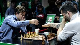 Magnus Carlsen, left, gets ready to play against Ian Nepomniachtchi on Day 2 of the FIDE World Blitz Chess Championship in New York on December 31, 2024.