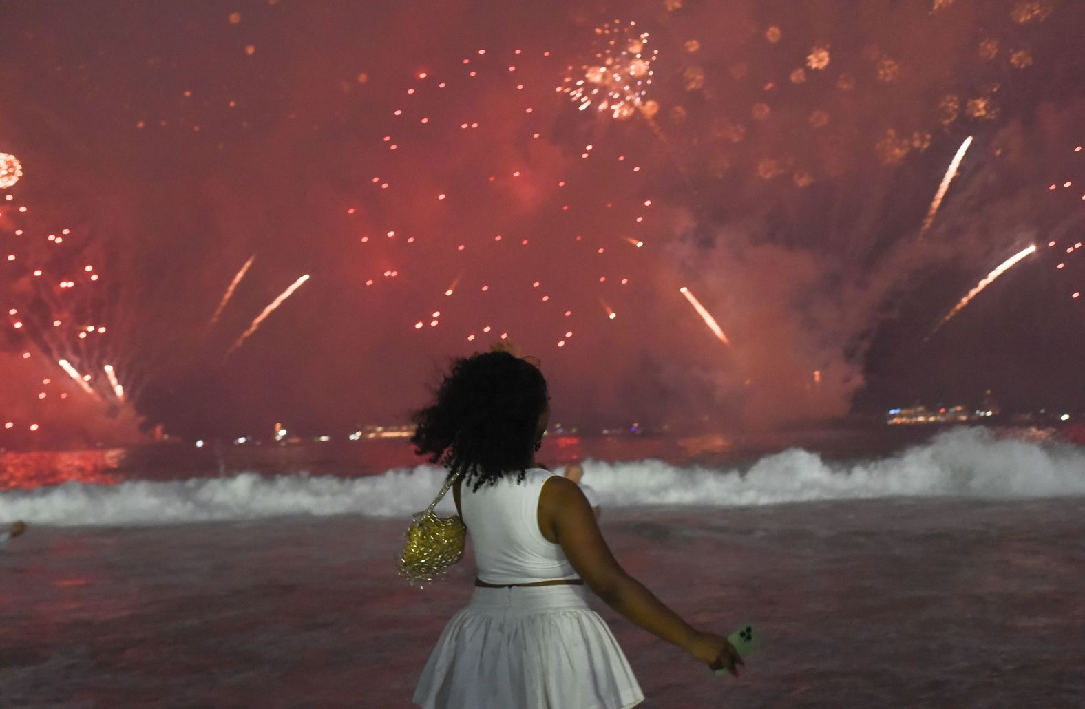 A woman watches a fireworks display on Copacabana beach in Rio de Janeiro, Brazil.