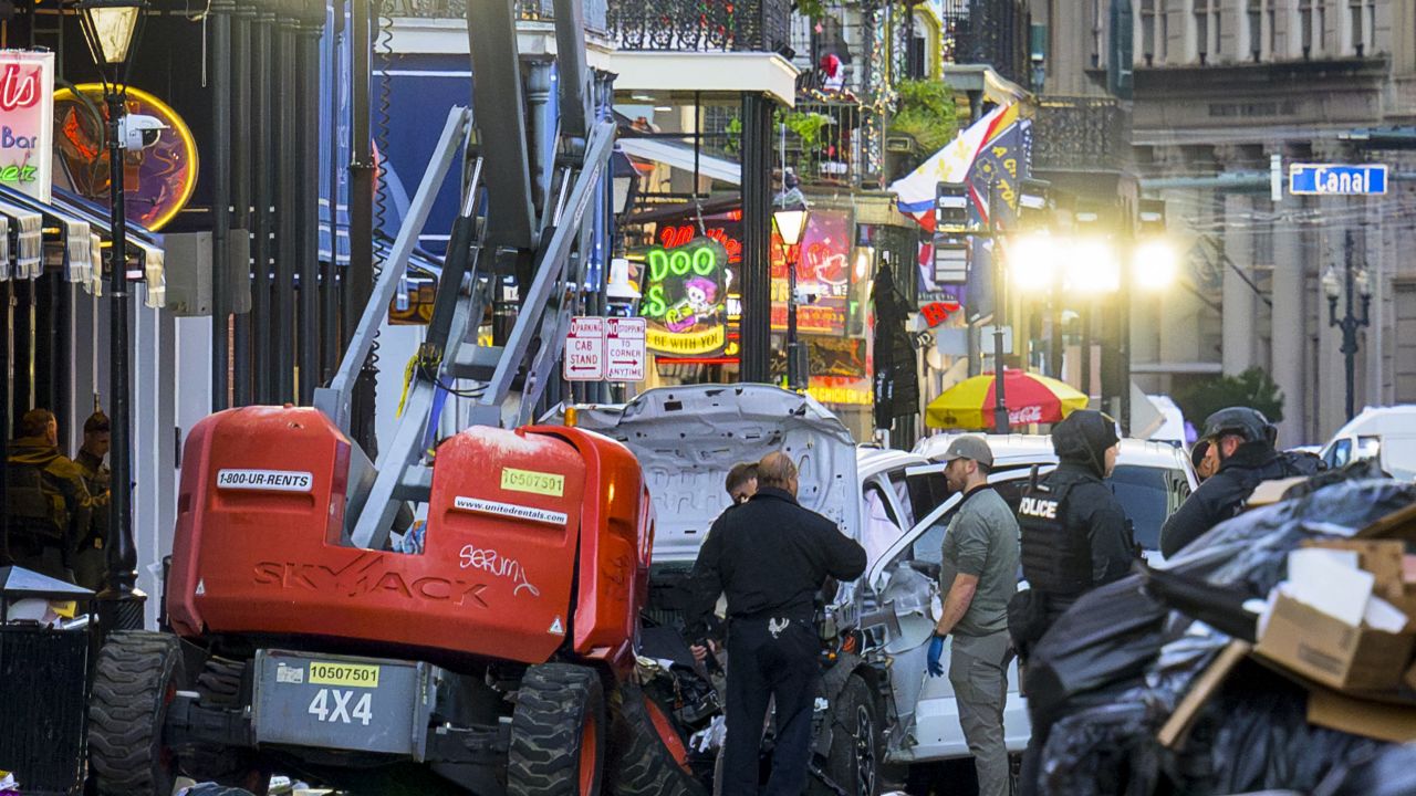 TOPSHOT - EDITORS NOTE: Graphic content / Police investigators surround the white Ford F-150 pickup truck that crashed into a work lift after allegedly driving into a crowd of New Year's revelers in the French Quarter of New Orleans, Louisiana, on January 1, 2025. At least 10 people were killed and 30 injured Wednesday when a vehicle plowed overnight into a New year's crowd in the heart of the thriving New Orleans tourist district, authorities in the southern US city said. (Photo by Matthew HINTON / AFP) (Photo by MATTHEW HINTON/AFP via Getty Images)