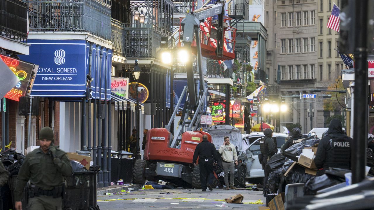 EDITORS NOTE: Graphic content / Police investigators surround the white Ford F-150 pickup truck that crashed into a work lift after allegedly driving into a crowd of New Year's revelers in the French Quarter of New Orleans, Louisiana, on January 1, 2025. At least 10 people were killed and 30 injured Wednesday when a vehicle plowed overnight into a New year's crowd in the heart of the thriving New Orleans tourist district, authorities in the southern US city said. (Photo by Matthew HINTON / AFP) (Photo by MATTHEW HINTON/AFP via Getty Images)