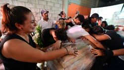 Football teammates of Ismael Arroyo, 15, mourn around his coffin during his wake and that of his brother Josue, 14, two of the four minors who had been missing for three weeks since disappearing during a military operation while playing football, in Guayaquil, Ecuador, on January 1, 2025. Genetic tests on charred bodies found near an Ecuador military base confirm they are those of four boys, aged between 11 and 15, taken by soldiers three weeks ago, officials said on December 31. That same day, the 16 soldiers suspected to be involved in the disappearance -- who had been put in military detention -- were ordered into custody by a criminal court. (Photo by Marcos PIN / AFP) (Photo by MARCOS PIN/AFP via Getty Images)