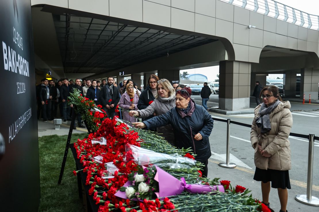 People lay flowers in memory of the victims of the disaster near Kazakhstan's Aktau airport.