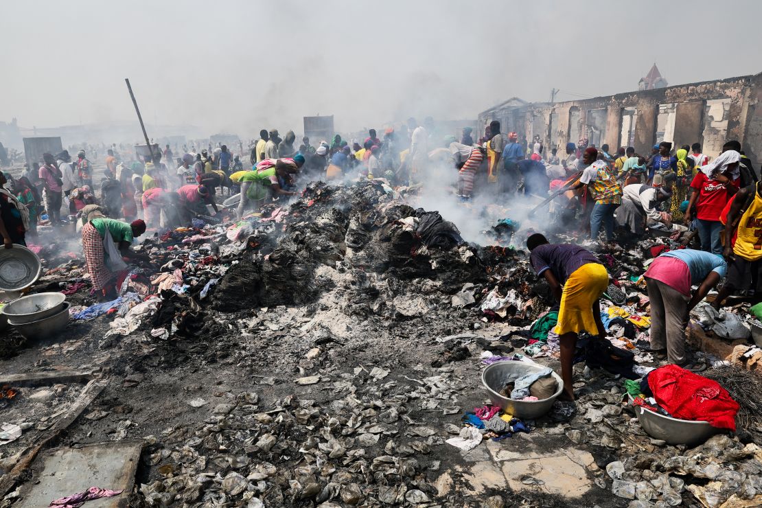 People try to salvage items from the burned down secondhand clothing market at Kantamanto in Accra, Ghana, on January 2, 2025. The fire at the Kantamanto market began in the early morning hours, destroying a large part of the area and displacing thousands of traders. (Photo by Nipah Dennis / AFP) (Photo by NIPAH DENNIS/AFP via Getty Images)