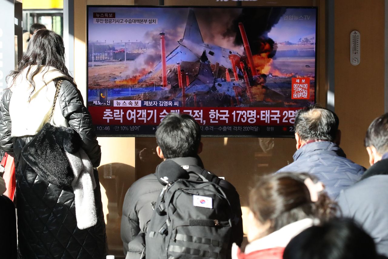 People watch a news broadcast on the plane crash, in Seoul, South Korea on December 29.