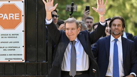 Venezuelan opposition leader Edmundo Gonzalez Urrutia (L) waves to ers next to Uruguay's President Luis Lacalle Pou after a meeting at the Suarez and Reyes presidential residence in Montevideo on January 4, 2025. Edmundo Gonzalez Urrutia traveled to Uruguay on Saturday to meet with President Luis Lacalle Pou, following his meeting with Argentina's President Javier Milei, on a regional tour to drum up  ahead of President Nicolas Maduro's swearing-in for a third term. (Photo by Santiago Mazzarovich / AFP) (Photo by SANTIAGO MAZZAROVICH/AFP via Getty Images)