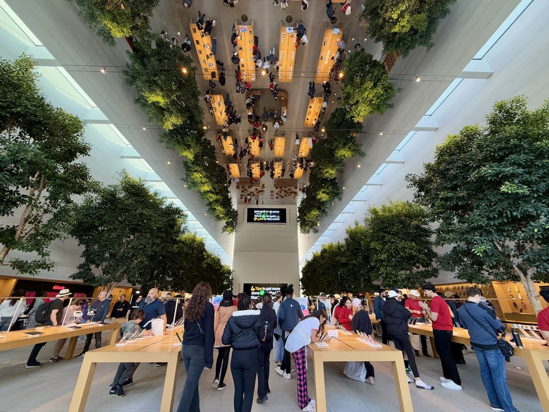 People are reflected in a mirrored ceiling at the Apple Store at the Grove shopping center in Los Angeles, California, on January 4, 2025.