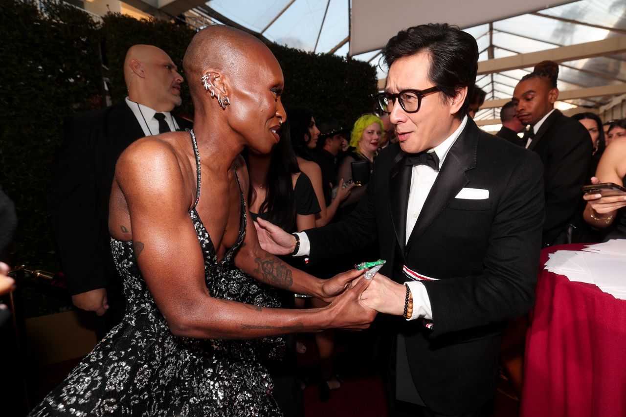 Cynthia Erivo and Ke Huy Quan greet each other near the red carpet.