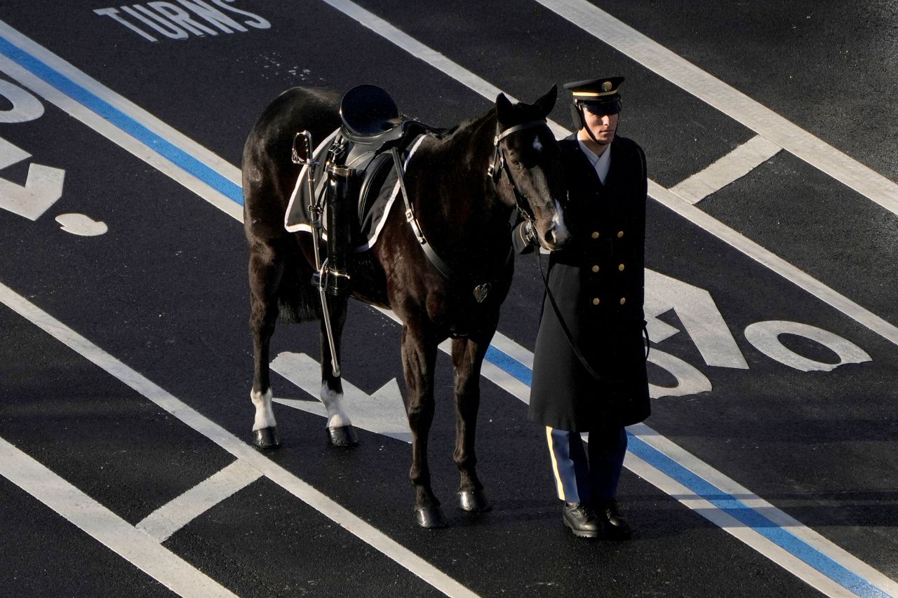 A riderless horse with boots reversed in the stirrups,  alongside a member of the military, escorted the caisson carrying former President Jimmy Carter's casket from the Navy Memorial to the Capitol on January 7.