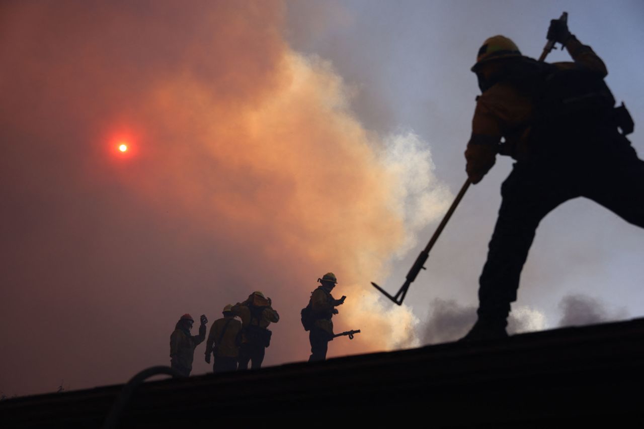 Firefighters work as a fire burns in Pacific Palisades, California, on Tuesday.