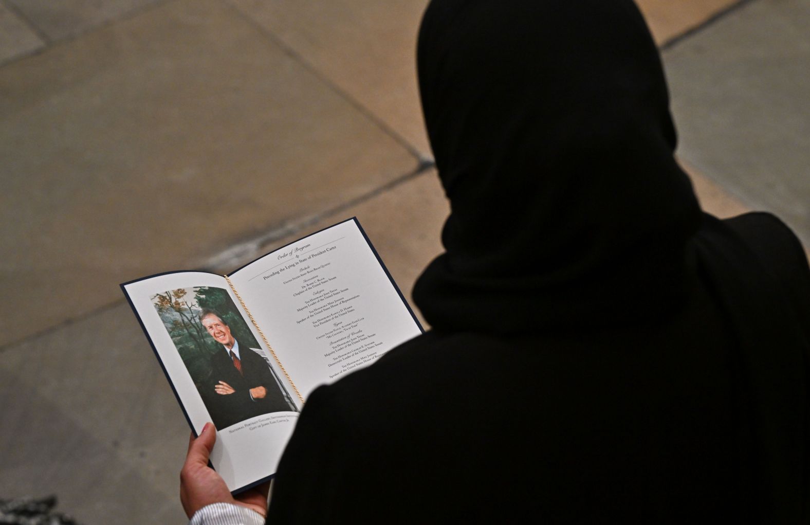 A guest looks at a program during the Carter ceremony at the Capitol on January 7.