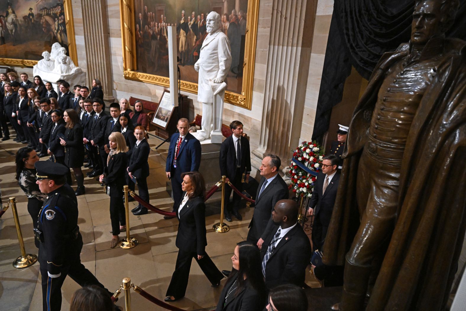 Vice President Harris, bottom, arrives for the memorial service at the Capitol on January 7. Behind her are her husband, Doug Emhoff, and House Speaker Mike Johnson.