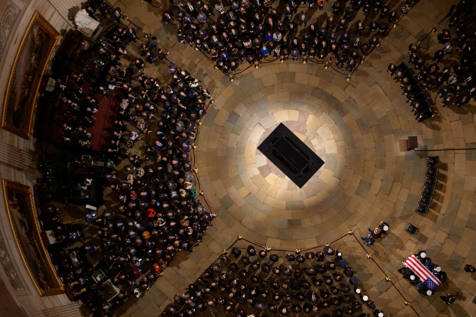 People sit around Carter's casket at the Capitol.