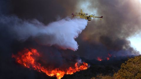 A firefighting plane makes a drop on the Palisades fire in Pacific Palisades on January 7, 2024.