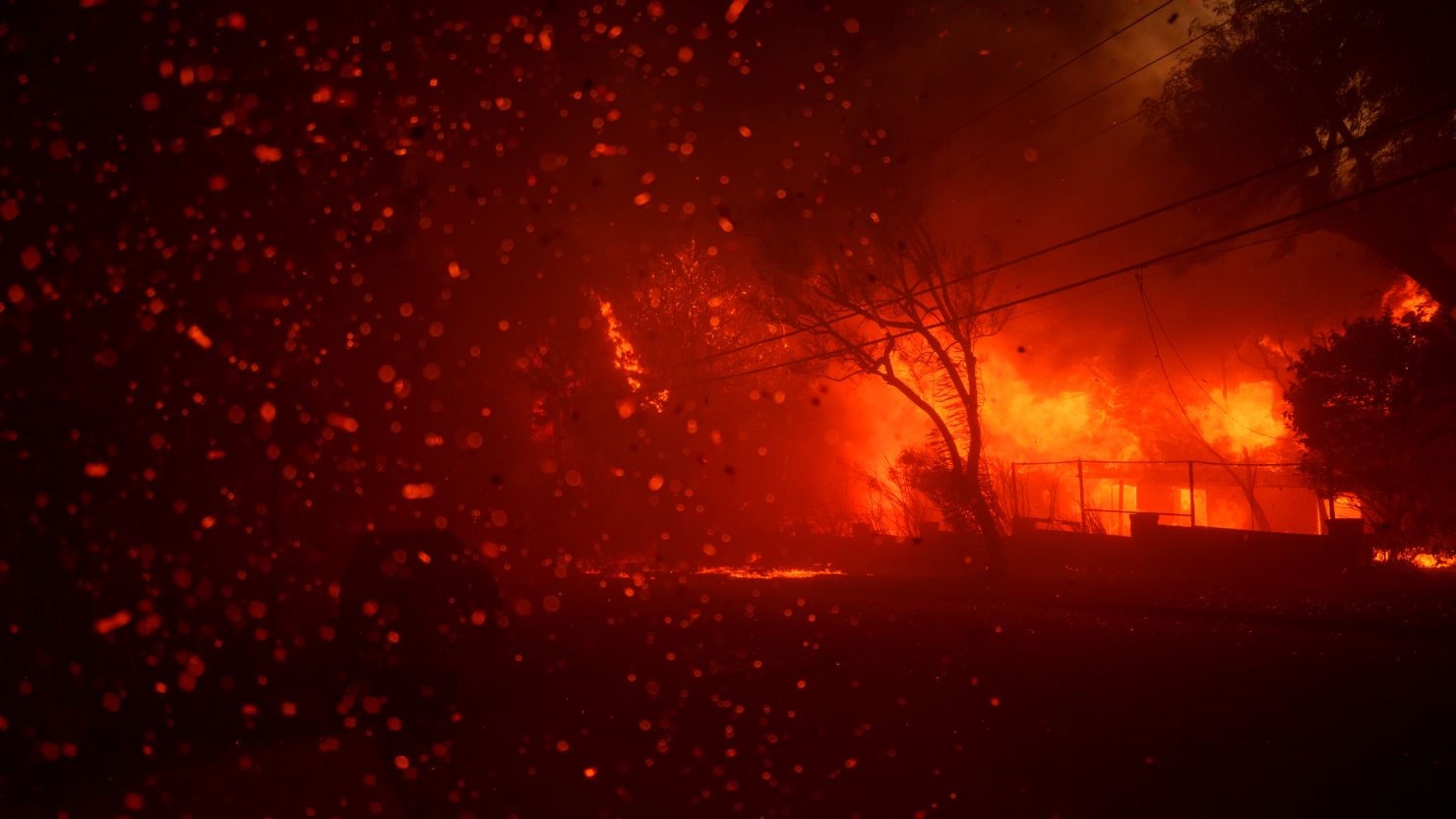 Flames from the Palisades Fire burn homes on January 7.