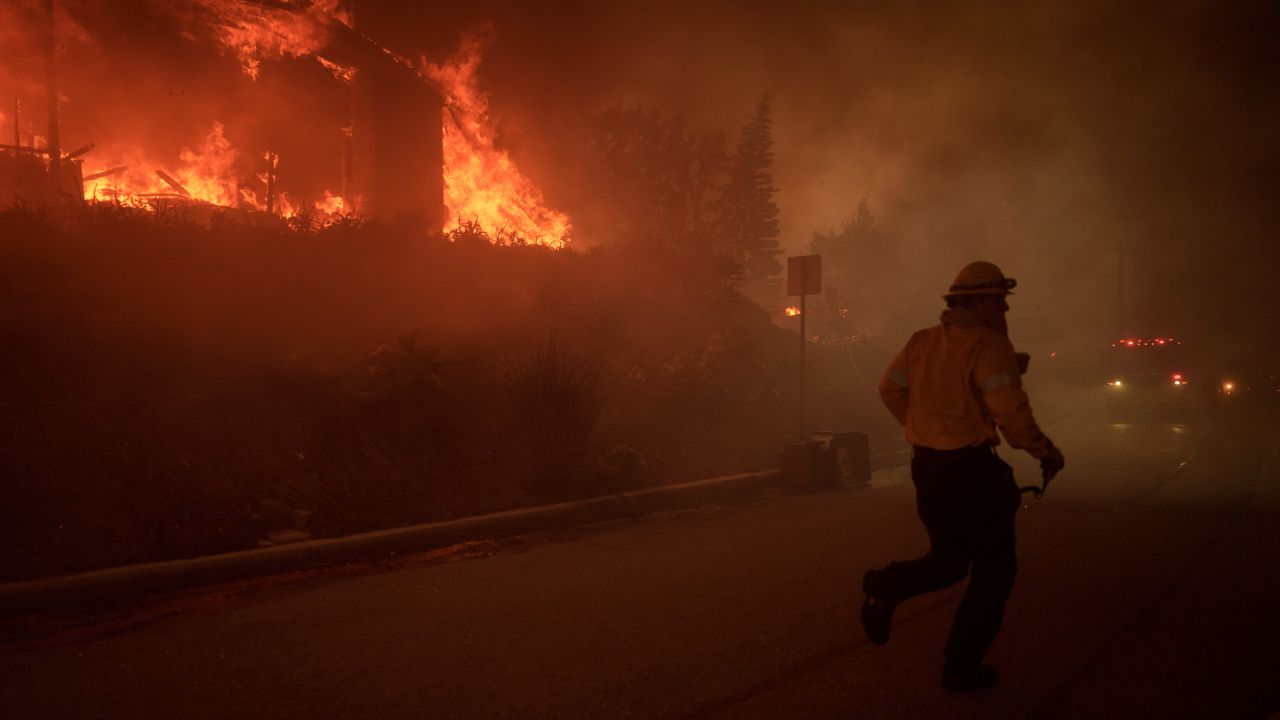 LOS ANGELES, CALIFORNIA - JANUARY 7: A firefighter battles flames from the Palisades Fire on January 7, 2025 in the Pacific Palisades neighborhood of Los Angeles, California. The fast-moving wildfire is threatening homes in the coastal neighborhood amid intense Santa Ana Winds and dry conditions in Southern California. (Photo by Eric Thayer/Getty Images)