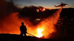 TOPSHOT - Fire personnel respond to homes destroyed while a helicopter drops water as the Palisades Fire grows in Pacific Palisades, California on January 7, 2025. Terrified residents caught in blazing neighbourhoods, influencers ignoring the ban on drones and the frightening unpredictability of the wildfires are just some of what journalists covering the fires ravaging Los Angeles for AFP have had to manage.
The United States' second-largest city has never faced a blaze of this scale, driven by an extreme autumn drought and fierce Santa Ana winds -- the strongest since 2011 -- that have turned dry hills into kindling, fuelling a relentless inferno that has raged for more than a week. (Photo by David Swanson / AFP) (Photo by DAVID SWANSON/AFP via Getty Images)