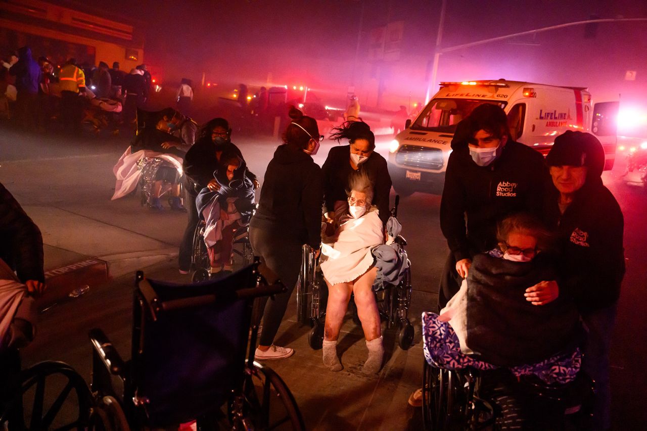 Elderly patients are quickly evacuated into emergency vehicles as embers and flames approach during the Eaton fire in Pasadena, California, on January 7.