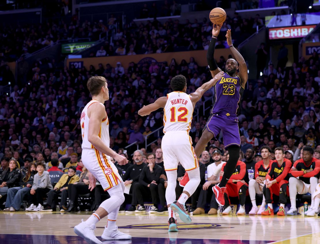 LeBron James scoring on a jumper over De'Andre Hunter and Bogdan Bogdanovic of the Atlanta Hawks.