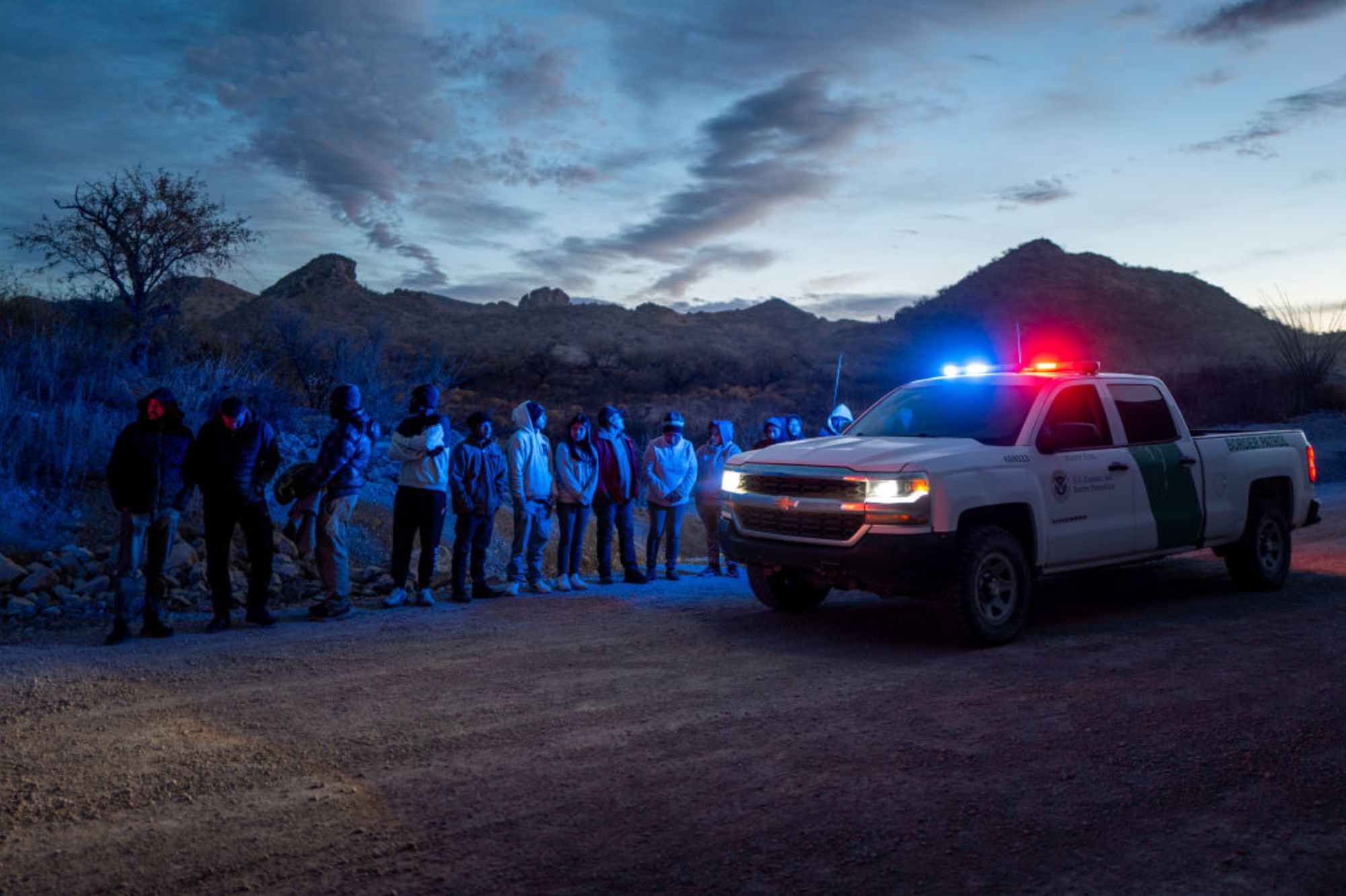 Migrantes de México y Guatemala son detenidos por agentes de la Patrulla Fronteriza y de Aduanas de EE.UU. tras cruzar una sección del muro fronterizo hacia EE.UU. el 4 de enero de 2025 en Ruby, Arizona.