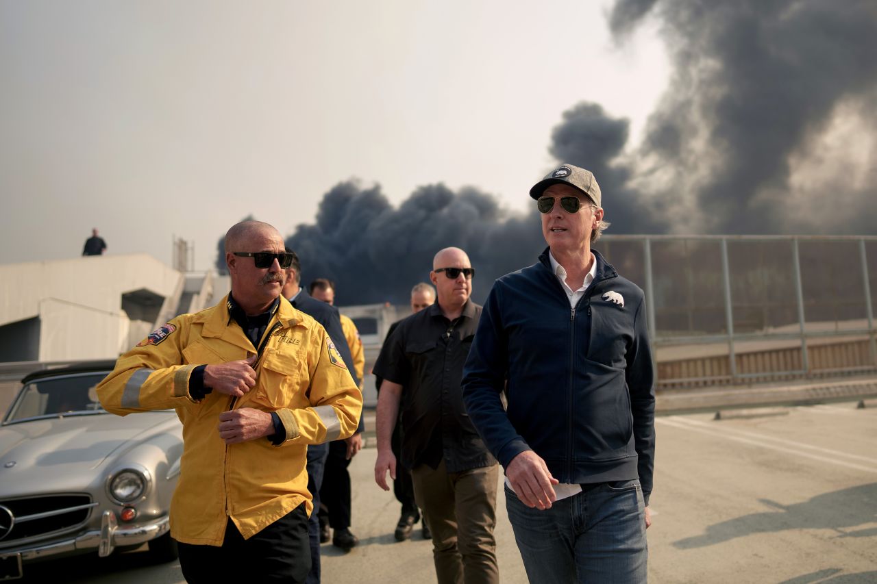 California Gov. Gavin Newsom, right, tours the downtown business district of Pacific Palisades as the Palisades Fire continues to burn in Los Angeles on January 8.