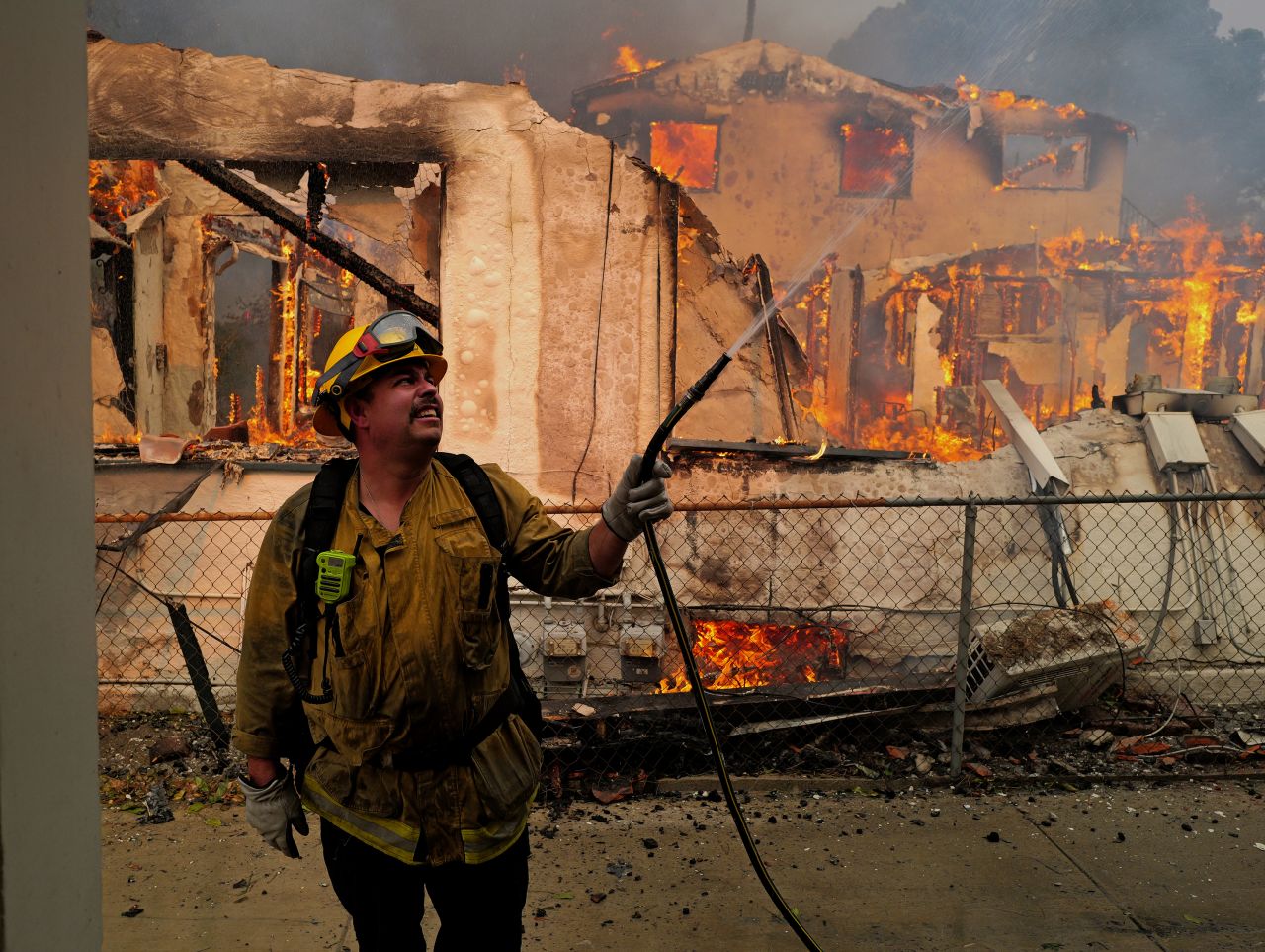 PASADENA, CALIFORNIA - January 08: A firefighter sprays water on a house to protect it from the Eaton Fire in the Altadena neighborhood on January 08, 2025 in PASADENA, CALIFORNIA. A spokesperson for the Los Angeles County Sheriff's Department said the death toll has risen, confirming three more people have died. Additionally, an undetermined amount of homes and businesses have been destroyed. (Photo by Nick Ut/Getty Images)