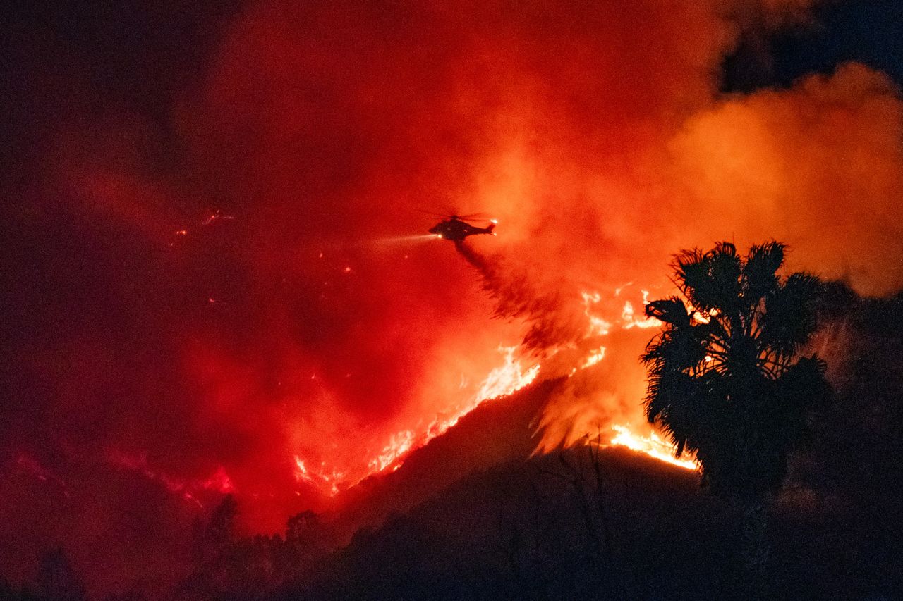 Helicopters are seen making water drops over the Sunset fire on January 8.