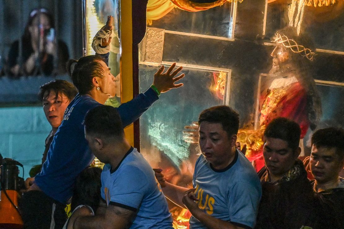 Devotees reach out to touch the Black Nazarene statue during ⁢the procession.