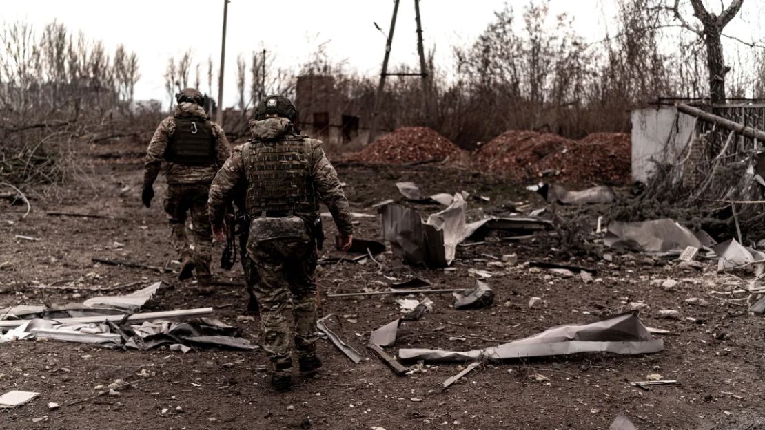 Soldados caminan entre escombros mientras civiles evacuan Pokrovsk, en el este de Ucrania.