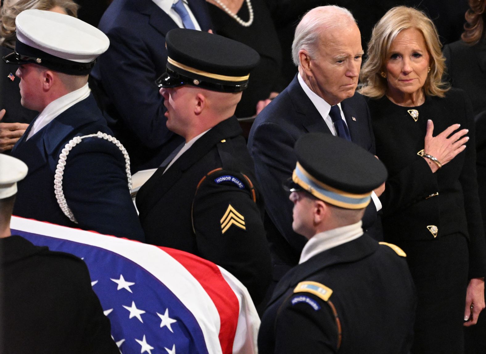 The casket passes by President Joe Biden and first lady Jill Biden at the end of the service.