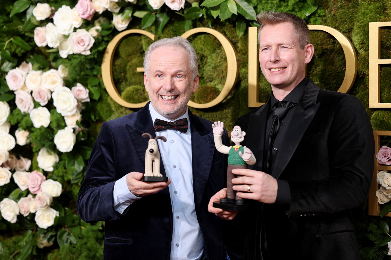 Nick Park and Merlin Crossingham hold figures of Wallace and Gromit on the Golden Globes red carpet on Sunday.