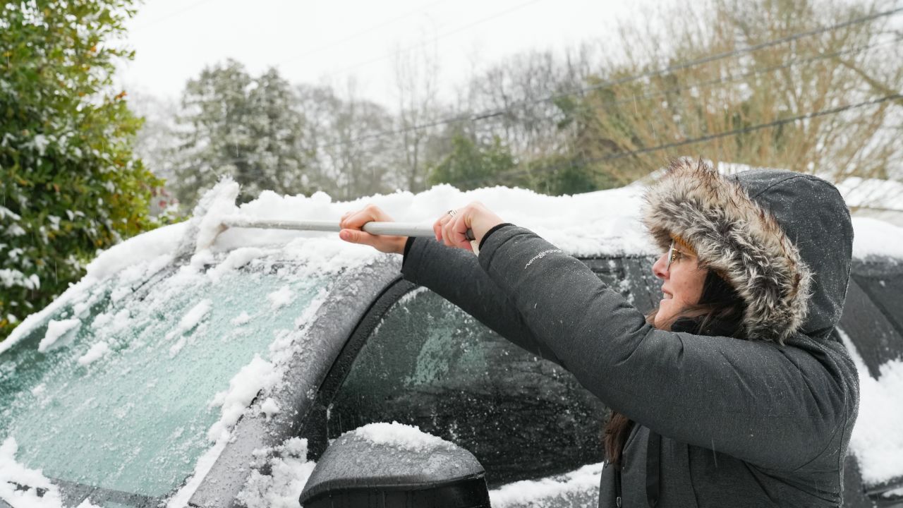 ATLANTA, GEORGIA - JANUARY 10: Atlanta resident Micaela Preston sweeps snow off her car on January 10, 2025 in Atlanta, Georgia. Atlanta has experienced a significant amount of snow but is bracing for the ice that is expected to follow. (Photo by Megan Varner/Getty Images)