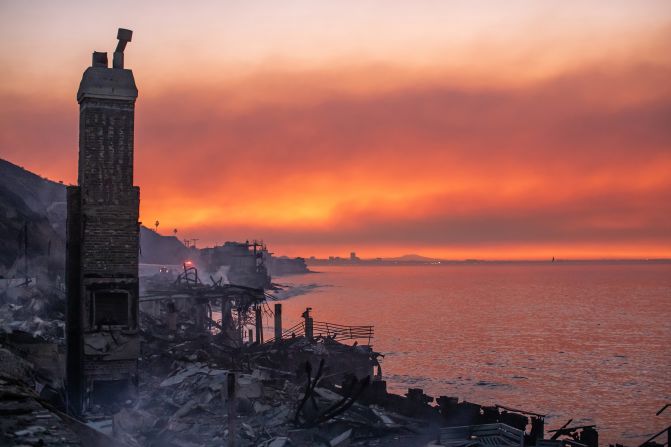 Wildfire smoke and burned houses are seen at dawn in the Pacific Palisades neighborhood of Los Angeles.