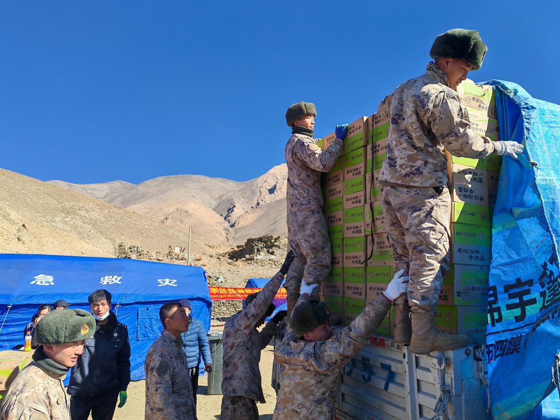 Soldiers help unload relief supplies from trucks at Chajiang Village on Wednesday.