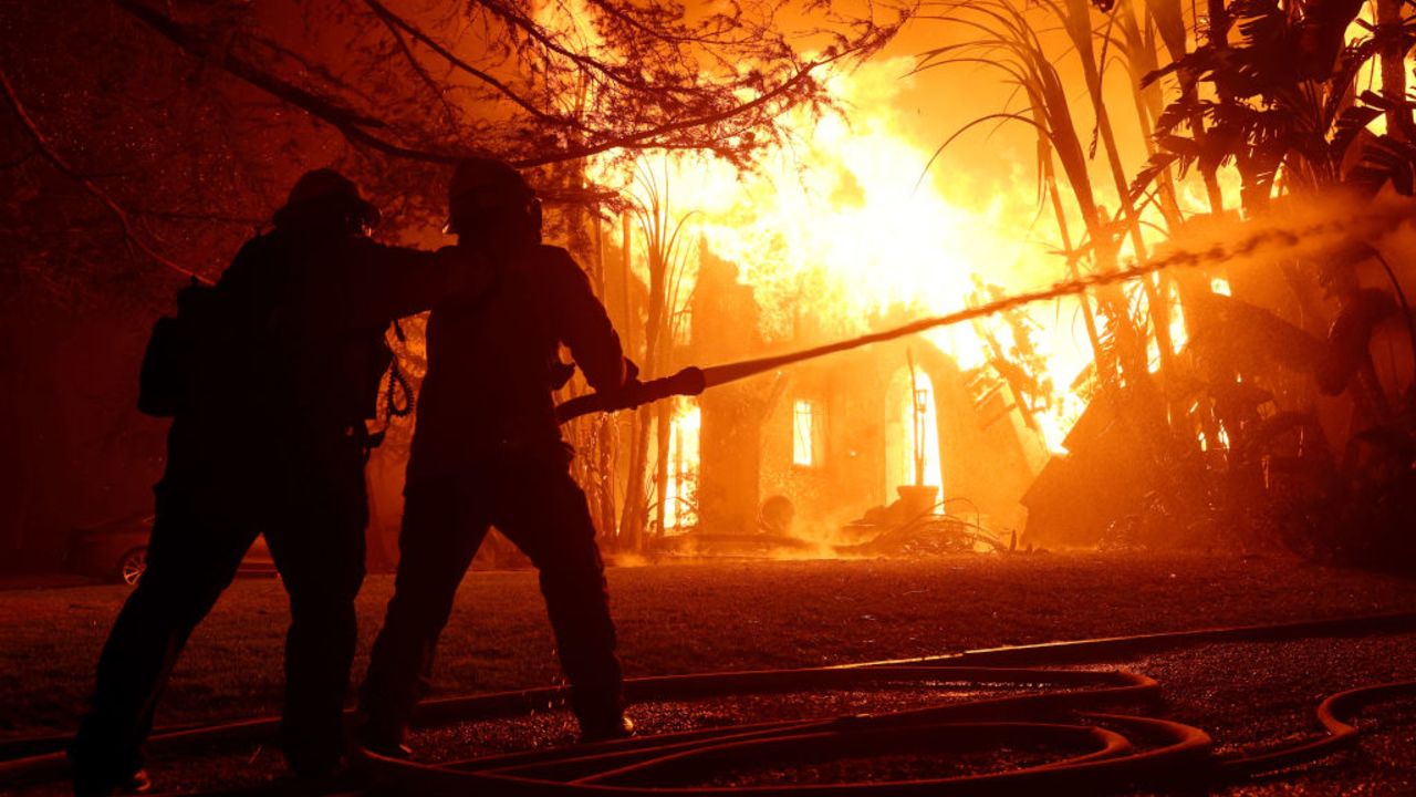 ALTADENA, CALIFORNIA - JANUARY 08: Los Angeles County firefighters spray water on a burning home as the Eaton Fire moved through the area on January 08, 2025 in Altadena, California. Fueled by intense Santa Ana Winds, the Palisades Fire has grown to over 2,900 acres and 30,000 people have been ordered to evacuate while a second fire has emerged near Eaton Canyon in Altadena. (Photo by Justin Sullivan/Getty Images)