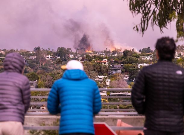 People in Santa Monica watch smoke and flames from the Palisades Fire.