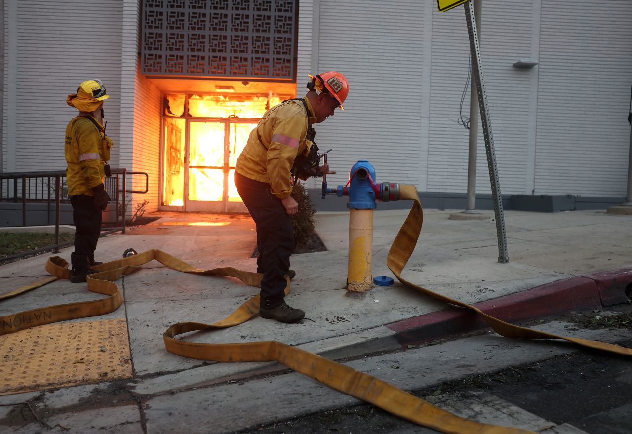 Los Angeles County firefighters try unsuccessfully to get water from a hydrant Wednesday as they battle the Eaton Fire in Altadena, California.