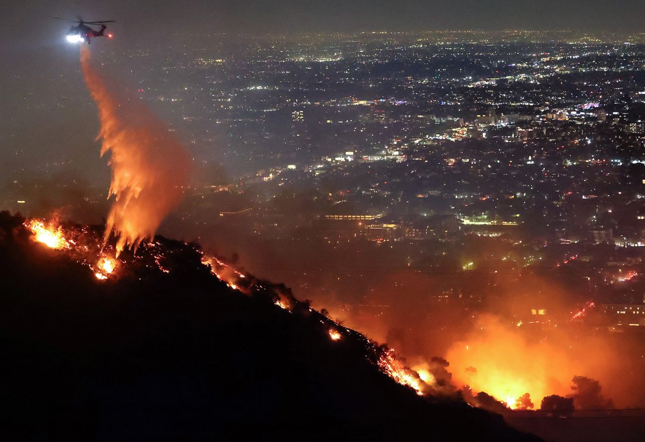 A firefighting helicopter drops water as the Sunset fire burns in the Hollywood Hills on January 8.